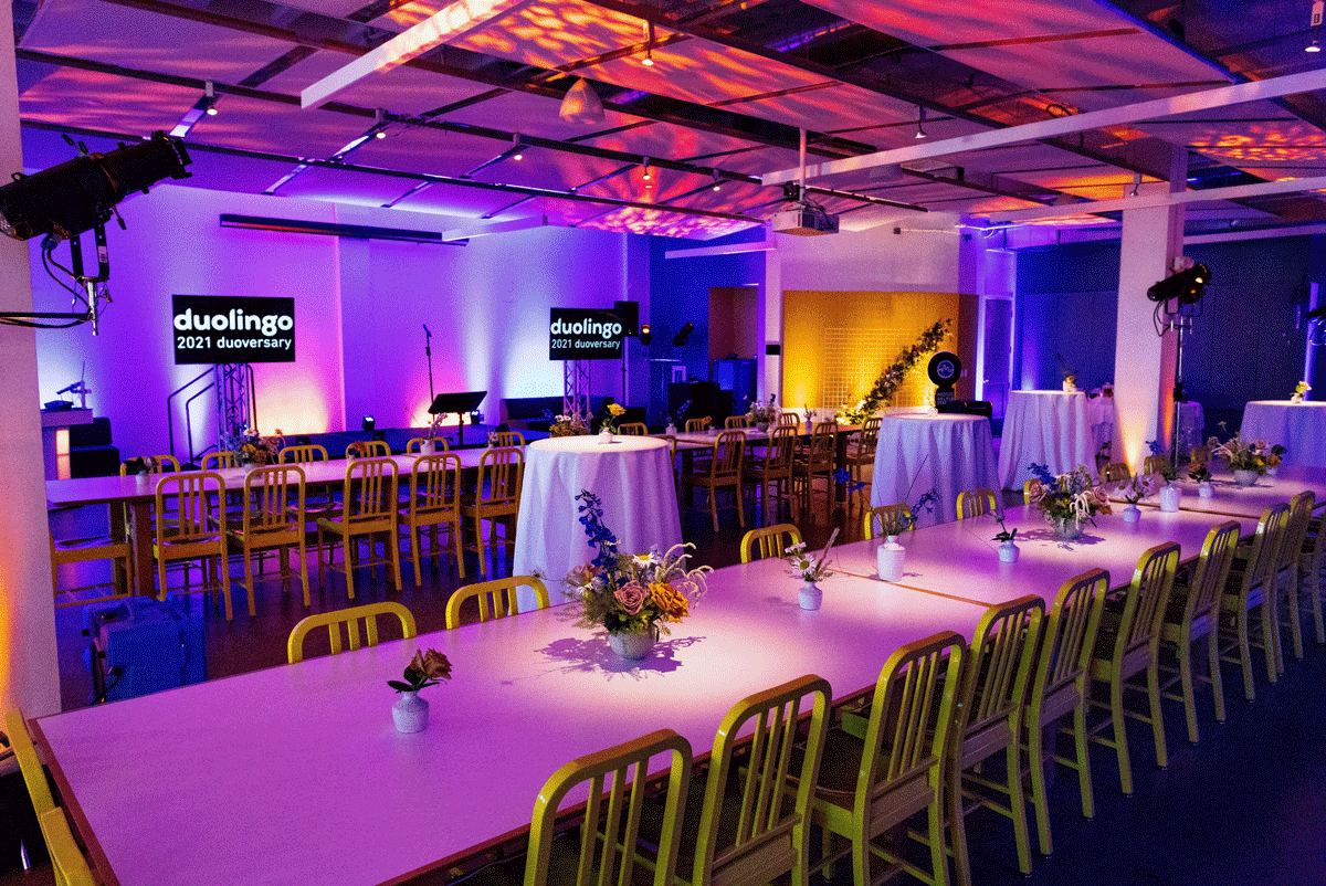 Tables Are Lined Together With Flowers And Pink Lighting