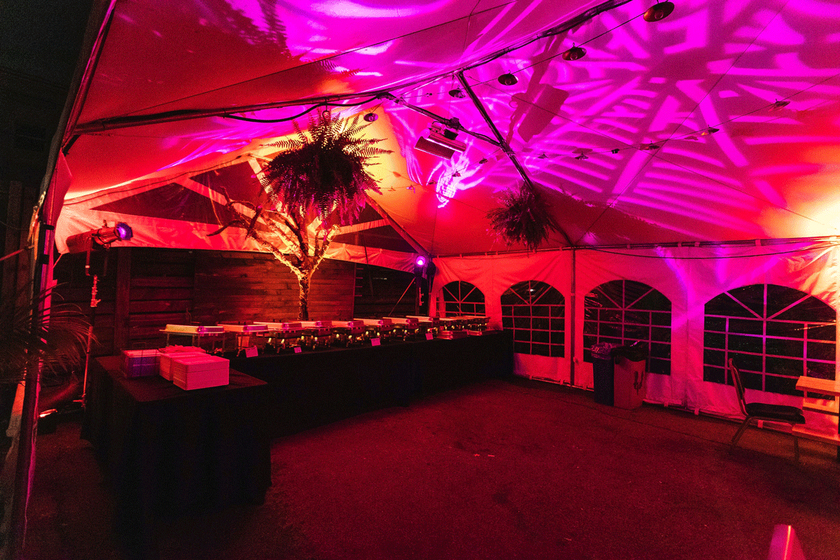 A large tent is illuminated with red and orange light