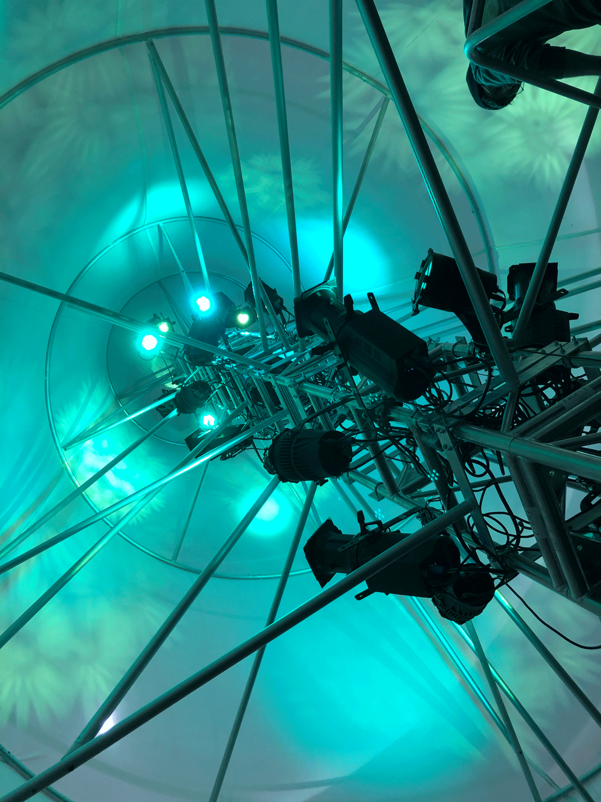 A truss tower is covered in blue and green lights
