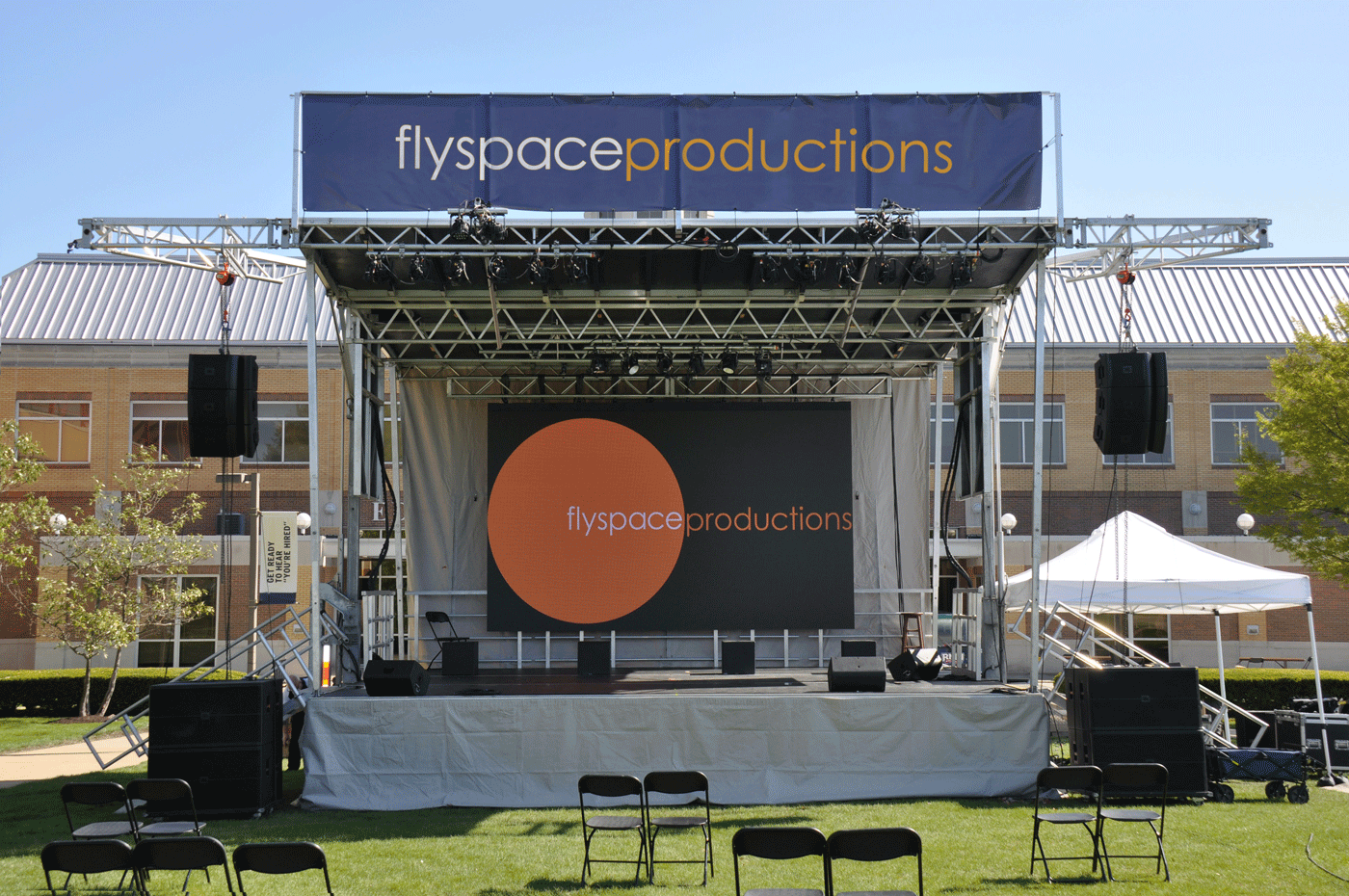 a stage with a video wall and banner stands alone