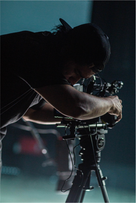 Camera person managing a camera set on a tripod