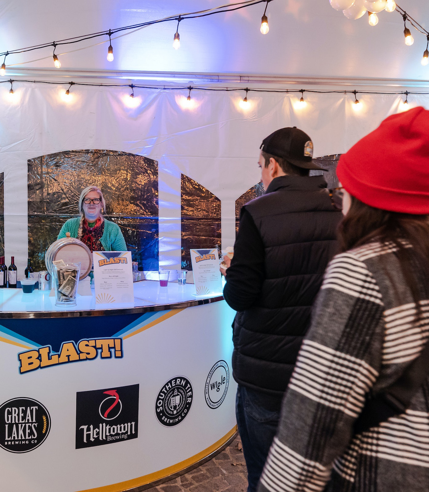 People wait in line to be served at a bar