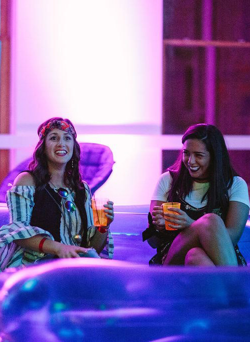 Two people sit together, laughing, on an inflatable couch