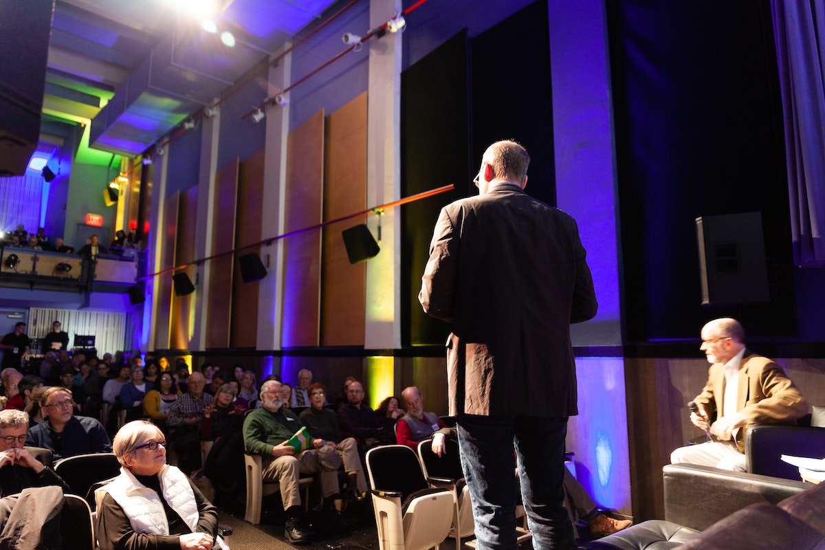 A person stands on a stage in front of an audience