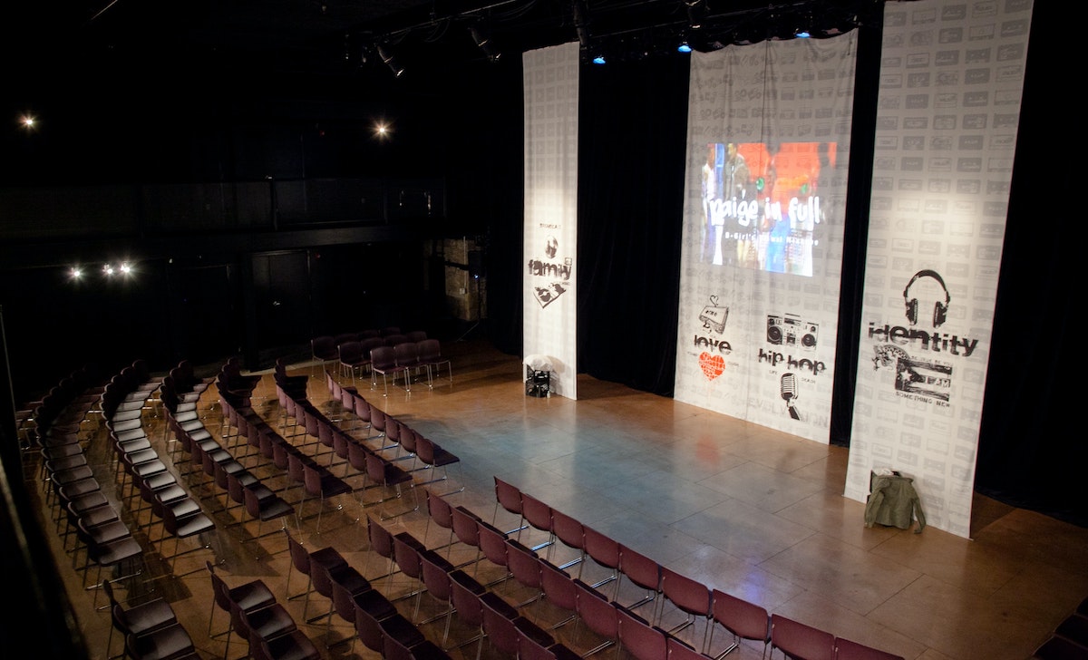 seats are arranged in front of a stage with tall banners