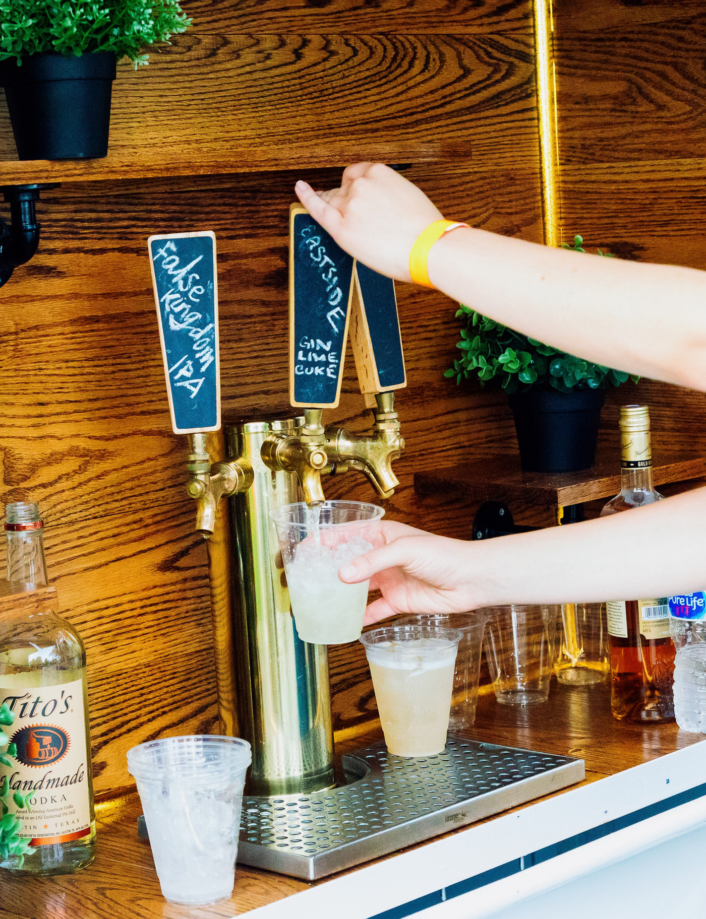 Two hands pour a drink into a cup from a tap