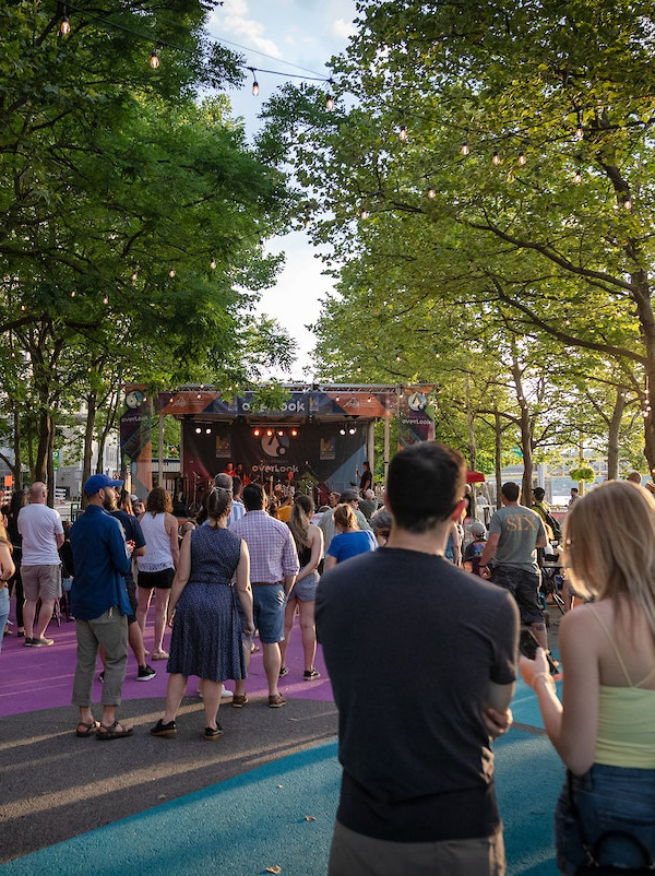 A crowd stands in front of an outdoor stage