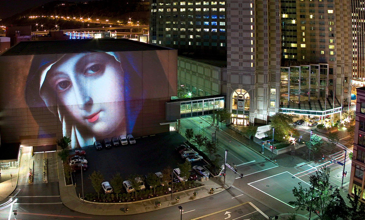 Lit up face of painting on side of building