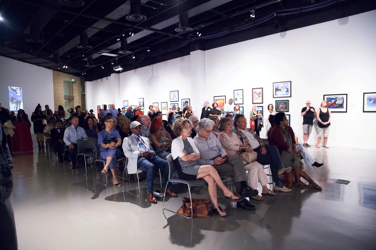 Large group of people sitting in an art gallery