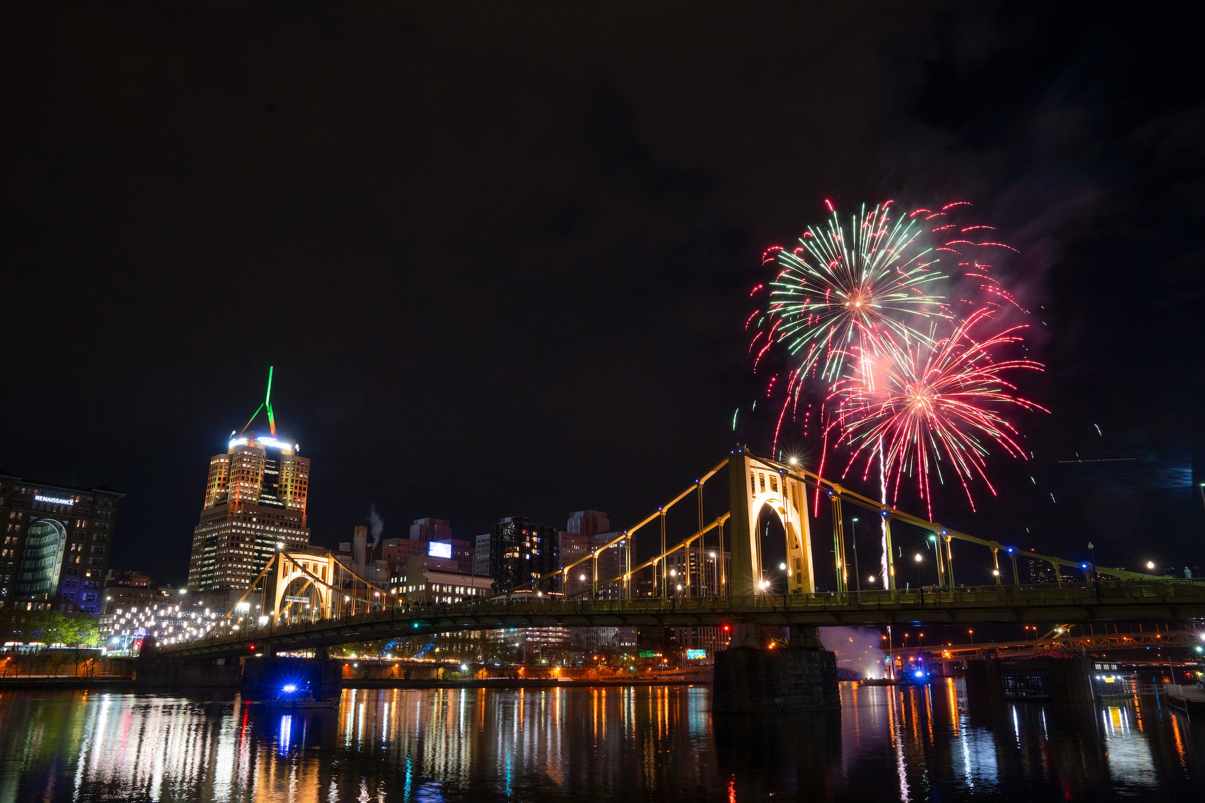 Fireworks explode above a bridge and city skyline