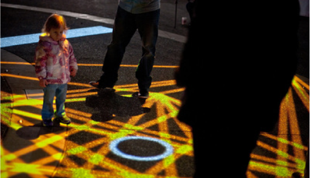 Small girl looks at laser beams on ground