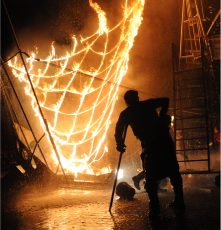 Silhouette of figure looking at flames on net