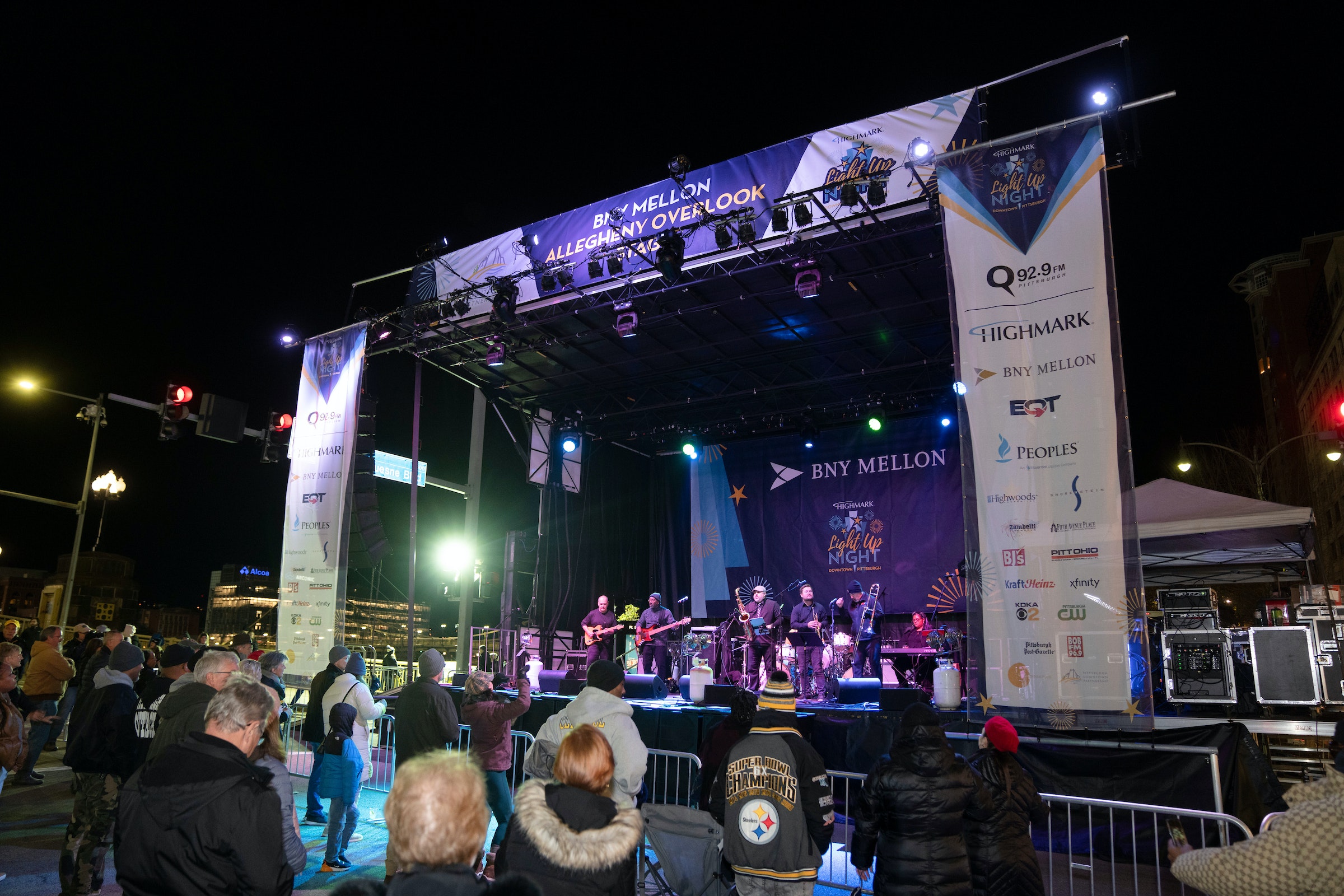 People watch performers on a stage at night time