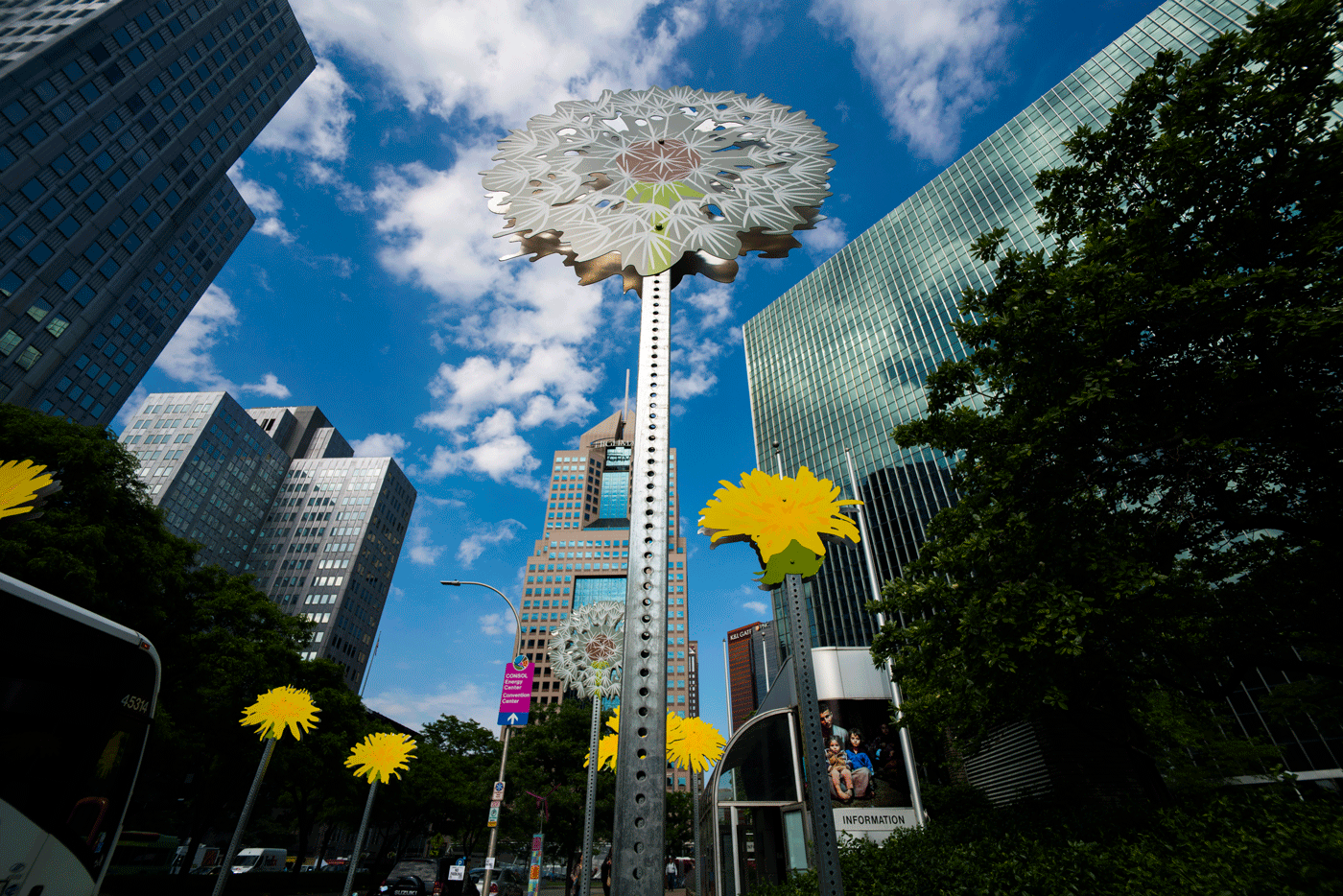Dandelion sculptures stand in front of the city skyline