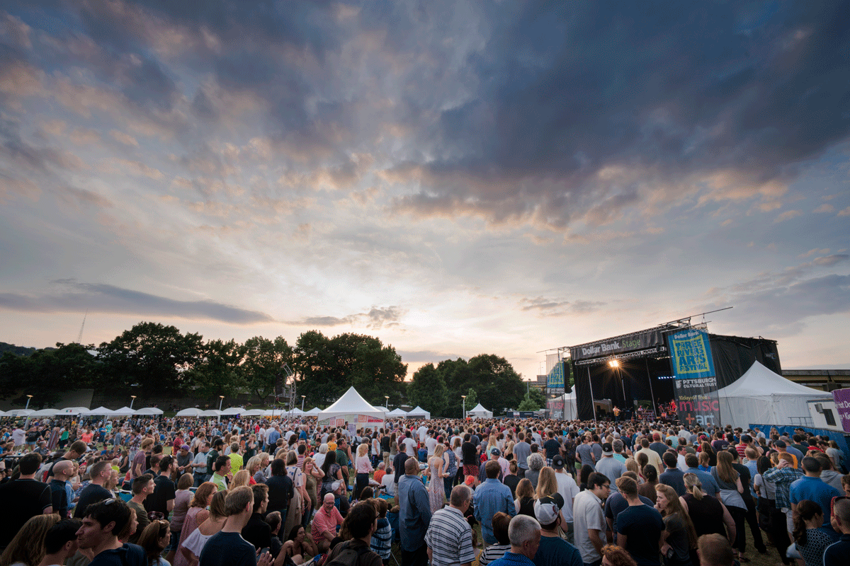 A large crowd is amassed in front of an outdoor stage